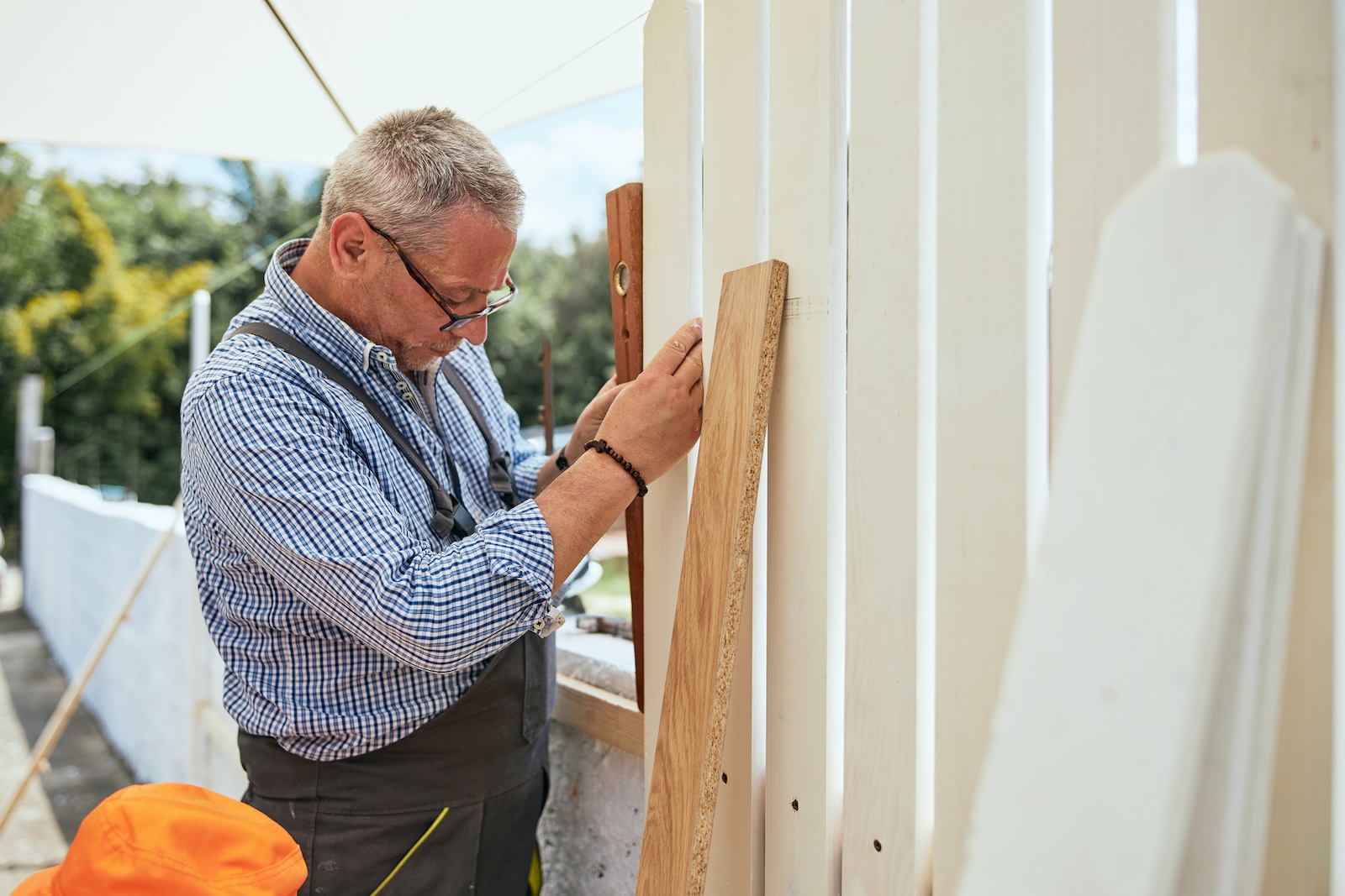 Man installing white vinyl fence without fence installation professionals at High & Tight Fencing